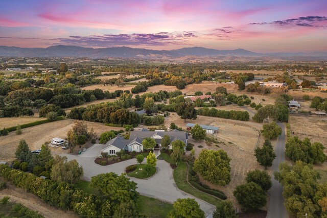 aerial view at dusk featuring a mountain view