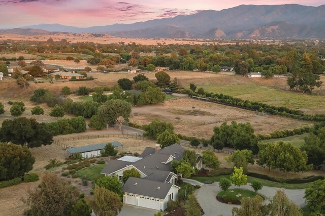 aerial view at dusk with a mountain view and a rural view