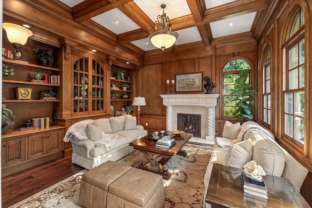 living area featuring coffered ceiling, dark wood-type flooring, wooden walls, and beamed ceiling