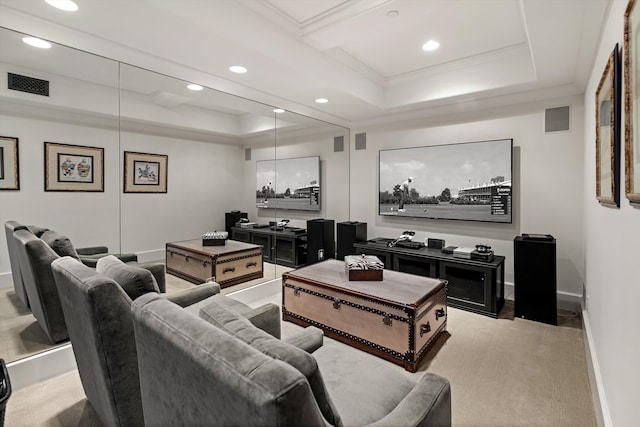 carpeted cinema featuring ornamental molding and a raised ceiling