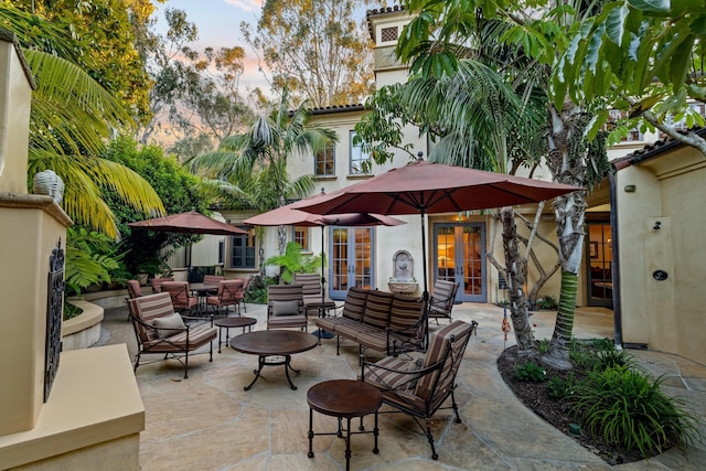 patio terrace at dusk featuring french doors and an outdoor hangout area