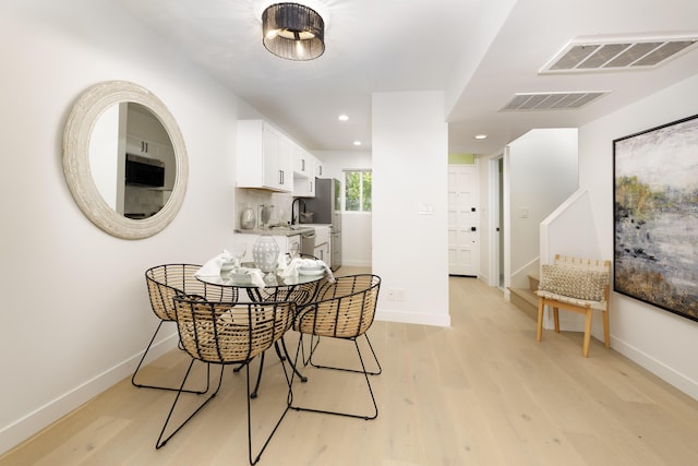 dining room featuring sink and light wood-type flooring