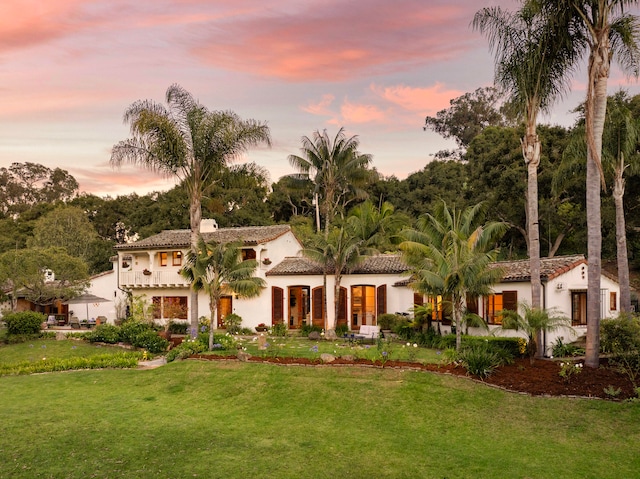 mediterranean / spanish house featuring a lawn