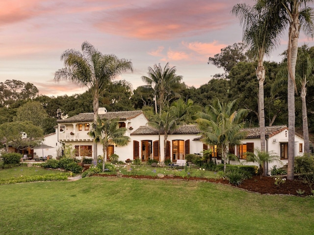 mediterranean / spanish-style house with a lawn