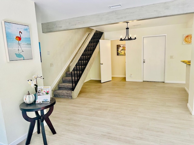 interior space with light wood-type flooring, stairway, baseboards, and visible vents