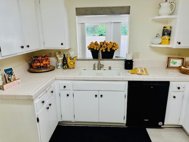 kitchen with white cabinets, dishwasher, tile countertops, and a sink