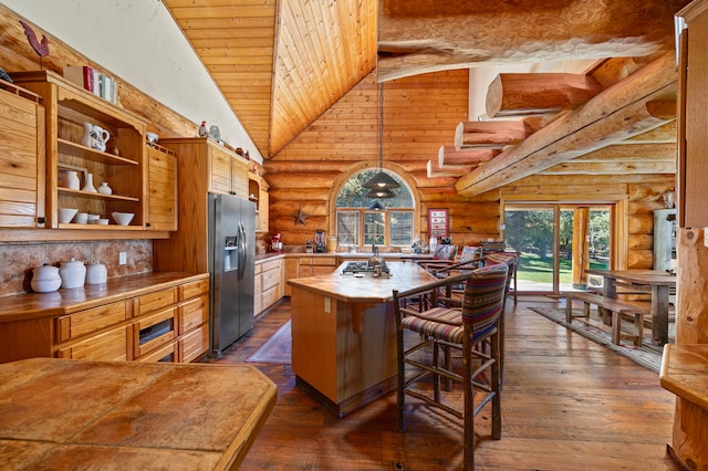 kitchen featuring stainless steel appliances, wood ceiling, dark hardwood / wood-style floors, high vaulted ceiling, and rustic walls