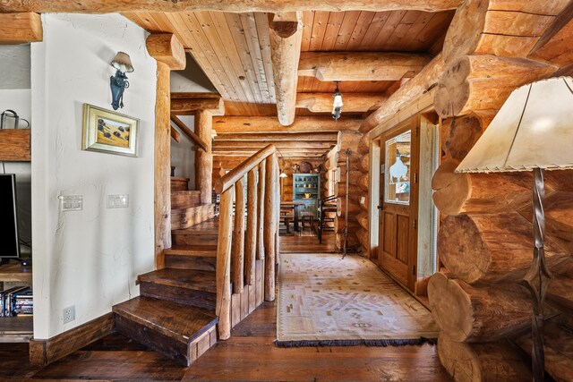 entrance foyer with rustic walls, beamed ceiling, wood-type flooring, and wooden ceiling