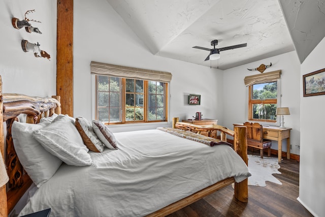 bedroom featuring lofted ceiling, dark wood-type flooring, ceiling fan, and multiple windows