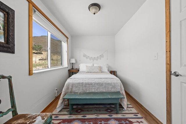 bedroom with baseboards and wood finished floors