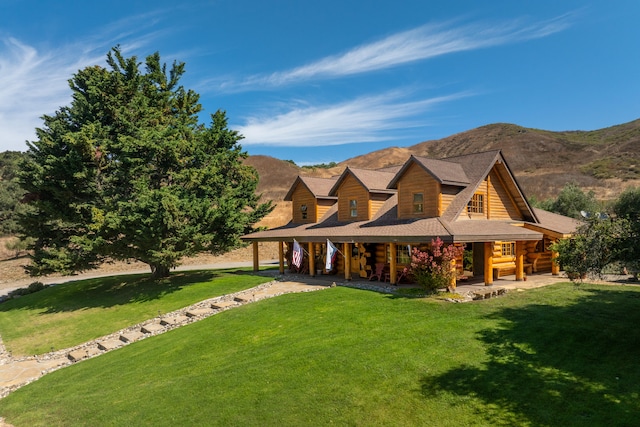 view of front of property with a mountain view and a front lawn