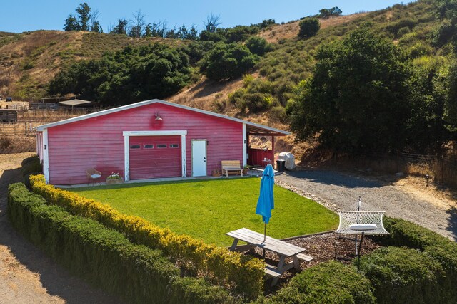 garage with a carport and a lawn