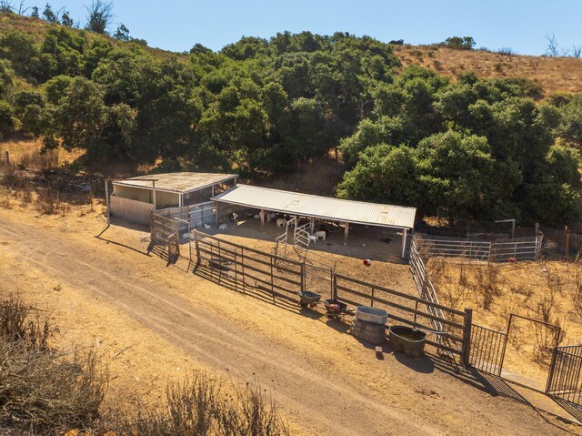 view of stable featuring a rural view and an outbuilding