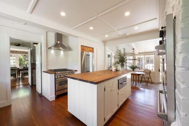 1259 Alamo Pintado Rd, Solvang, CA 93463 - kitchen with wood counters, high end appliances, wall chimney exhaust hood, white cabinetry, and beam ceiling