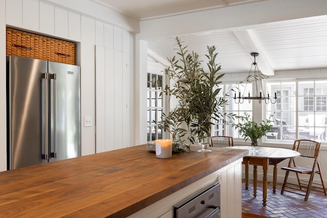 1259 Alamo Pintado Rd, Solvang, CA 93463 - kitchen featuring wood counters, high end refrigerator, brick floors, a chandelier, and white cabinetry