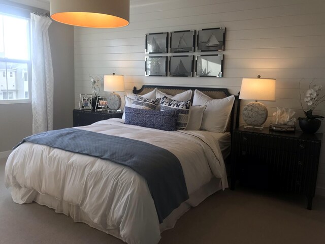 carpeted bedroom featuring wood walls