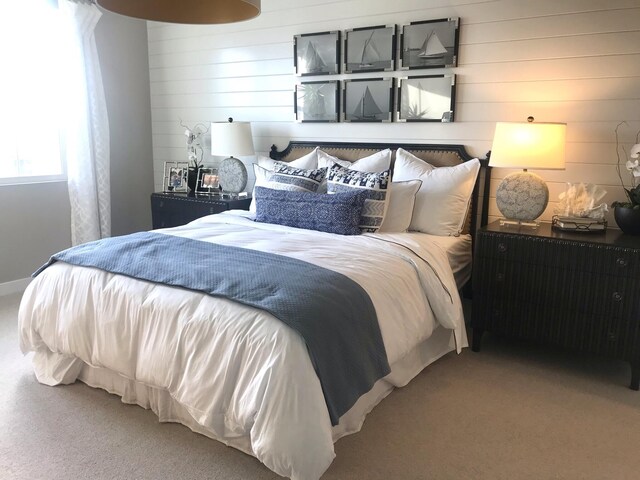 bedroom featuring wooden walls and carpet floors