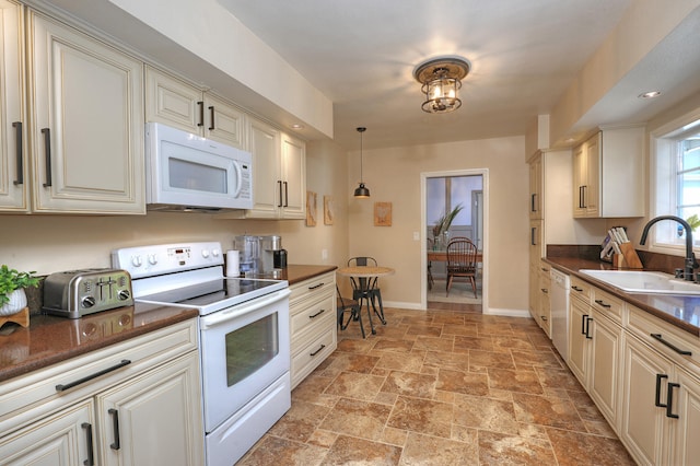 kitchen with light tile patterned floors, sink, white appliances, and decorative light fixtures