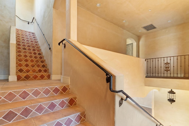 stairway featuring tile patterned flooring and visible vents