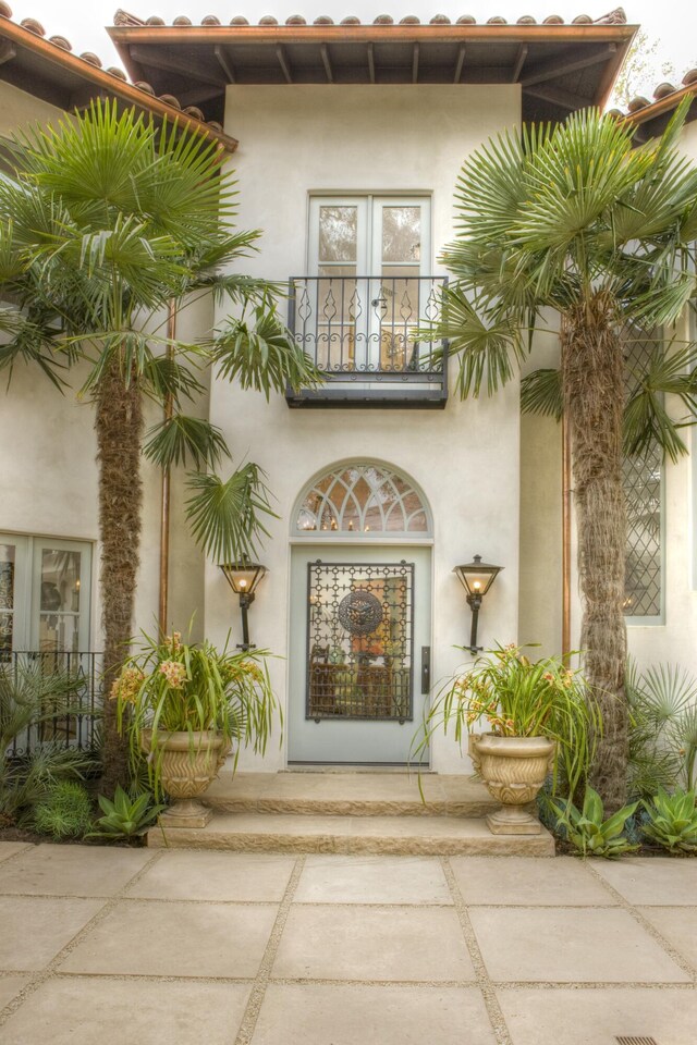 property entrance featuring a balcony and french doors