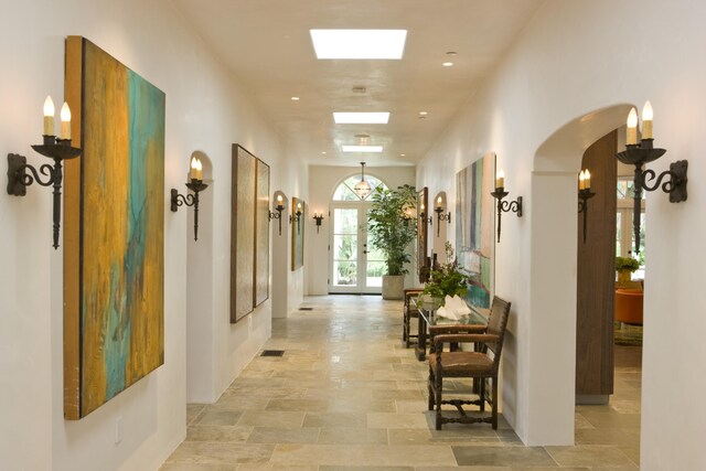 corridor featuring french doors and light tile patterned floors