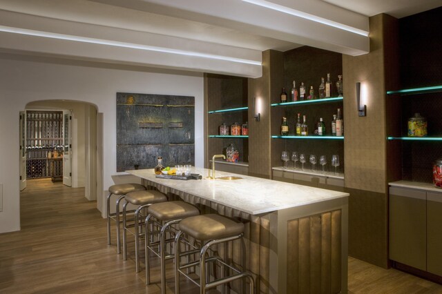 bar featuring sink and light hardwood / wood-style flooring