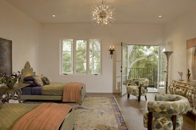 bedroom with access to outside, an inviting chandelier, and light hardwood / wood-style flooring