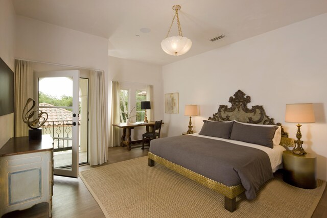 bedroom featuring hardwood / wood-style flooring, multiple windows, and access to outside