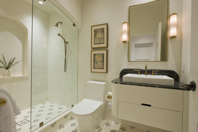 bathroom featuring tile patterned flooring, toilet, a shower, and vanity