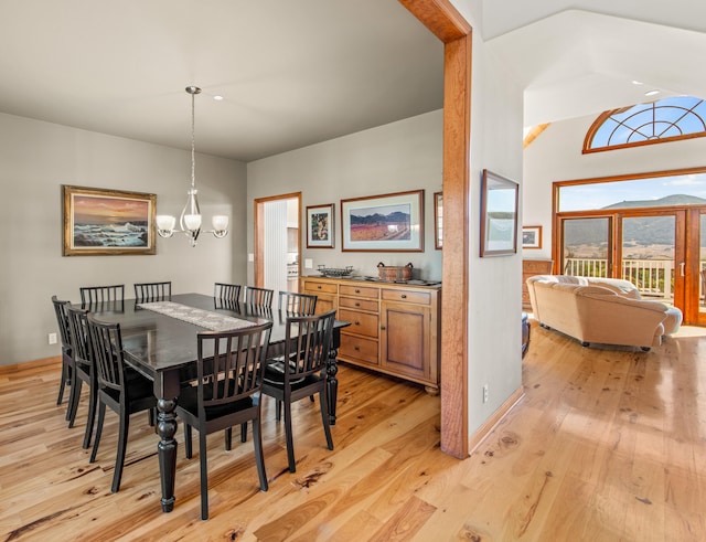 dining room featuring lofted ceiling, light hardwood / wood-style flooring, and a chandelier