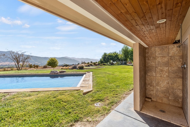 view of pool featuring a mountain view and a yard