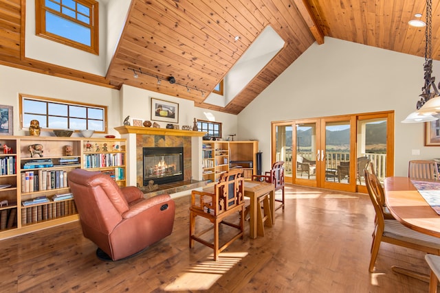 living room with a tiled fireplace, wooden ceiling, hardwood / wood-style floors, high vaulted ceiling, and beam ceiling