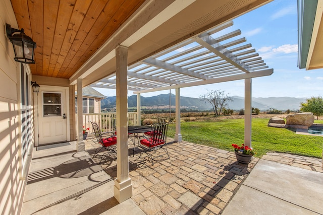 view of patio featuring a mountain view, a pergola, and a rural view