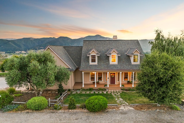 cape cod home featuring covered porch and a mountain view