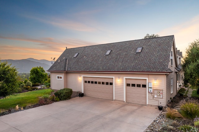 view of front of house with a mountain view, a yard, and a garage