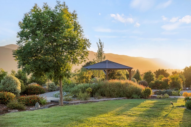 yard at dusk featuring a gazebo