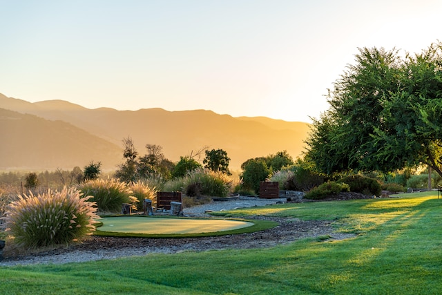 surrounding community with a yard and a mountain view