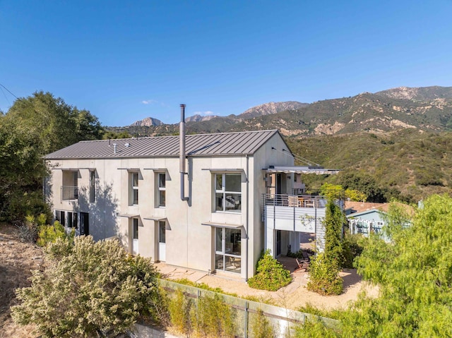 back of house featuring a balcony and a mountain view