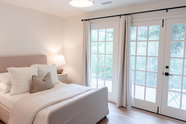 bedroom with hardwood / wood-style flooring, access to exterior, and french doors