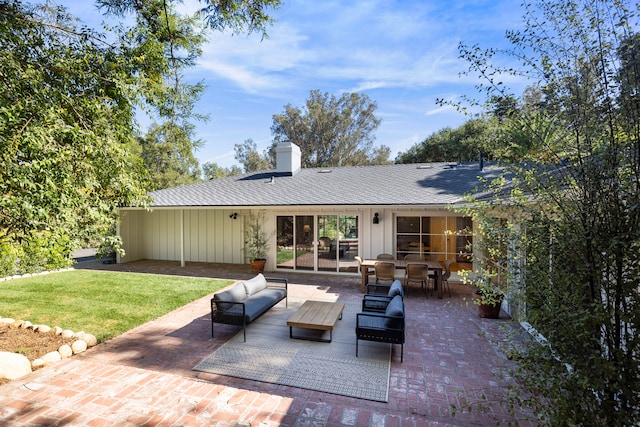 back of house featuring outdoor lounge area, a lawn, and a patio