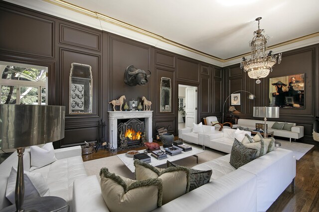 living room featuring hardwood / wood-style flooring, an inviting chandelier, and ornamental molding