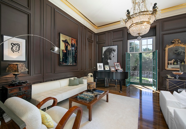 living room featuring crown molding, dark hardwood / wood-style flooring, and a chandelier