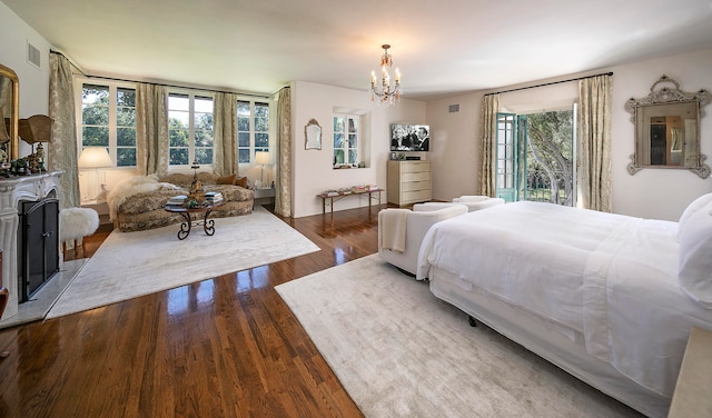 bedroom with dark wood-type flooring, access to exterior, and a chandelier