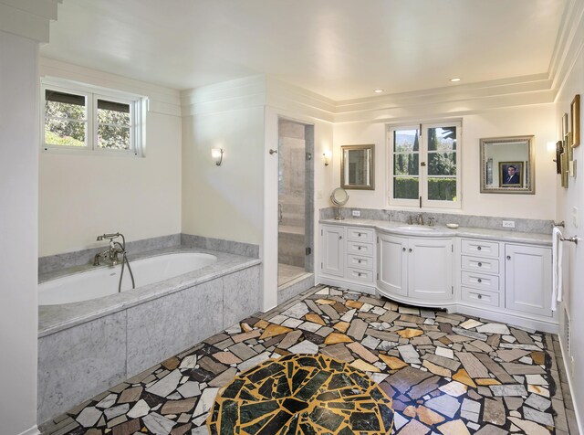 bathroom featuring ornamental molding, vanity, a wealth of natural light, and independent shower and bath