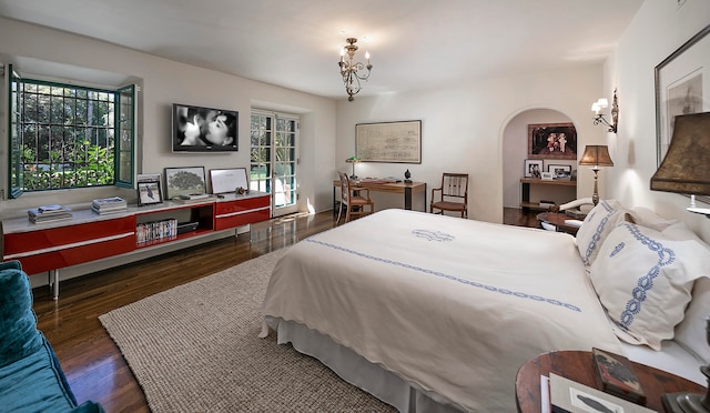 bedroom featuring dark wood-type flooring, multiple windows, and a notable chandelier