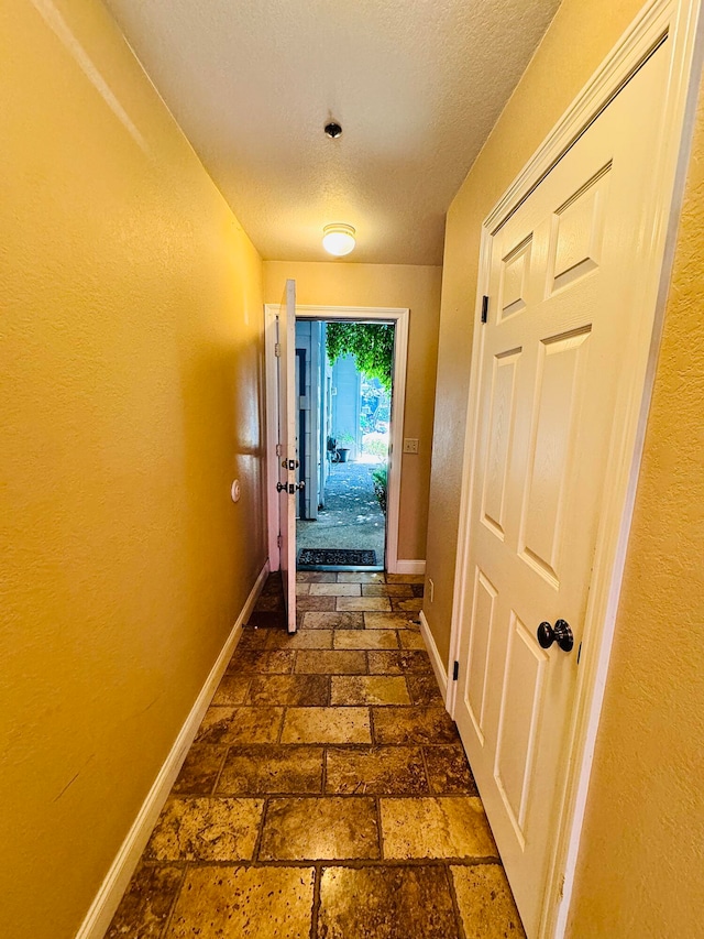 hall with a textured ceiling