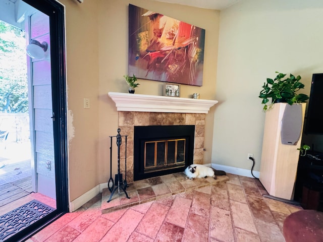 living room with a tiled fireplace and a healthy amount of sunlight