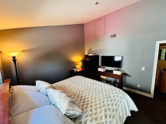 carpeted bedroom featuring lofted ceiling and a textured ceiling