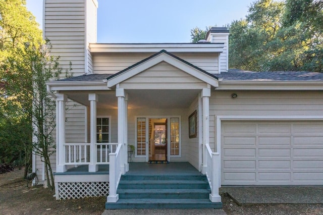 doorway to property featuring a garage and a porch