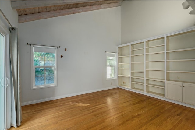 empty room featuring wooden ceiling, high vaulted ceiling, beam ceiling, and light hardwood / wood-style floors